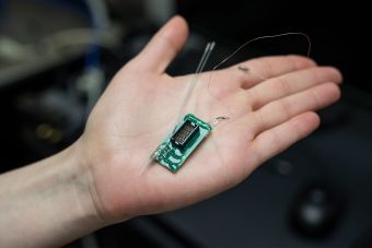 A researchers holds a device similar to the deep brain implant that will be tested.